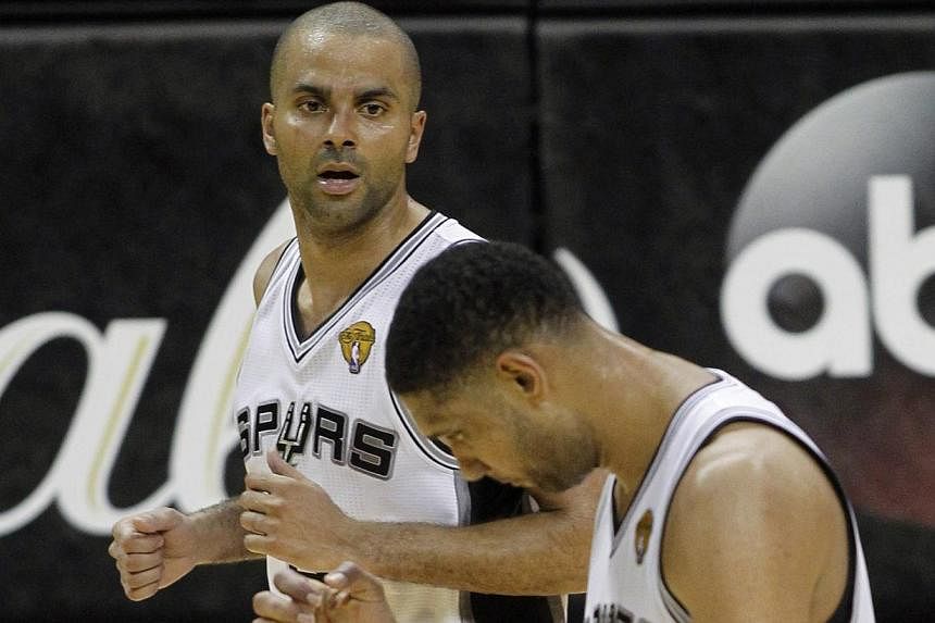 San Antonio Spurs' Tim Duncan (right) and Tony Parker of France celebrate during their win over the Miami Heat in Game 1 of their NBA Finals basketball series in San Antonio, Texas on June 5, 2014.&nbsp;Some torrid fourth-quarter shooting led by Dann