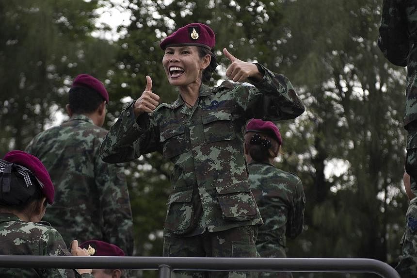 Thai soldiers sing as they stand on an army truck to entertain people at Victory monument in Bangkok on June 5, 2014. -- PHOTO: AFP