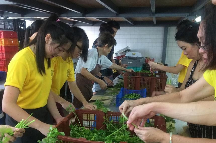 Pioneer Junior College student Lydia Phang (left) roped in 23 of her classmates to help prepare hot meals for the needy.