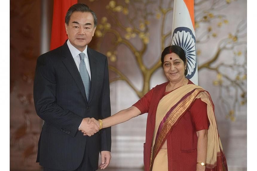 Visiting Chinese Foreign Affairs Minister Wang Yi (left) shakes hands with Indian Minister for External Affairs Sushma Swaraj during a meeting in New Delhi on June 8, 2014.&nbsp;India hailed talks with China on Sunday as a good step towards stronger 