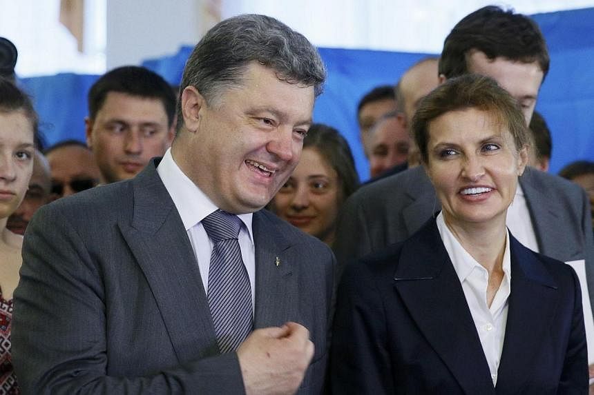 Ukrainian businessman, politician and presidential candidate Petro Poroshenko (left) and his wife Maryna (right), chat during voting in a presidential election at a polling station in Kiev May 25, 2014.&nbsp;With her natural elegance and confident ch