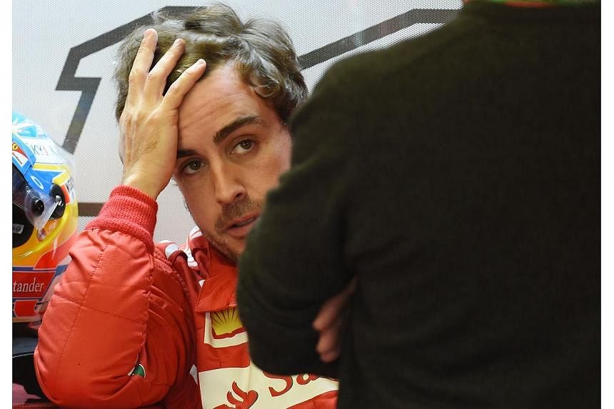 Ferrari driver Fernando Alonso of Spain in the pits at the Circuit Gilles Villeneuve in Montreal on June 6, 2014 during the first practice session for the Canadian Formula One Grand Prix. -- PHOTO: AFP