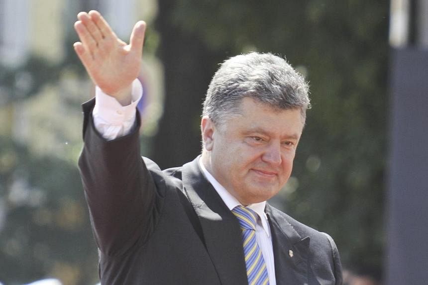 Ukraine's new president Petro Poroshenko (right) waves as he attends a flag raising ceremony after his inauguration in Kiev on June 7, 2014. -- PHOTO: REUTERS