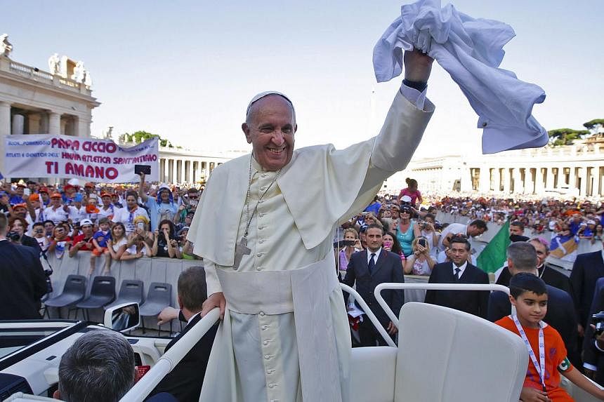 Pope Francis holds a scarf offered by faithful as he leads a special audience for members of CSI (Italian sport centres) in Saint Peter's Square at the Vatican June 7, 2014. -- PHOTO: REUTERS