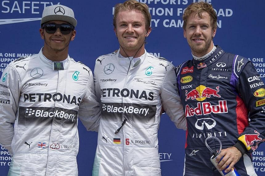 Pole position winner Mercedes driver Nico Rosberg (centre) of Germany stands with Mercedes driver Lewis Hamilton (left) of Britain and Red Bull driver Sebastian Vettel of Germany at the Circuit Gilles Villeneuve in Montreal on June 7, 2014 after the 
