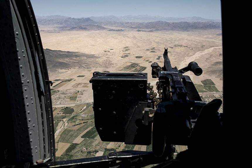 A file picture taken on June 2, 2014 shows a US Army helicopter gunner watching over the Afghan countryside while flying between Kandahar Airfield and Forward Operating Base Pasab in Kandahar. Afghanistan's air force is already woefully short of plan