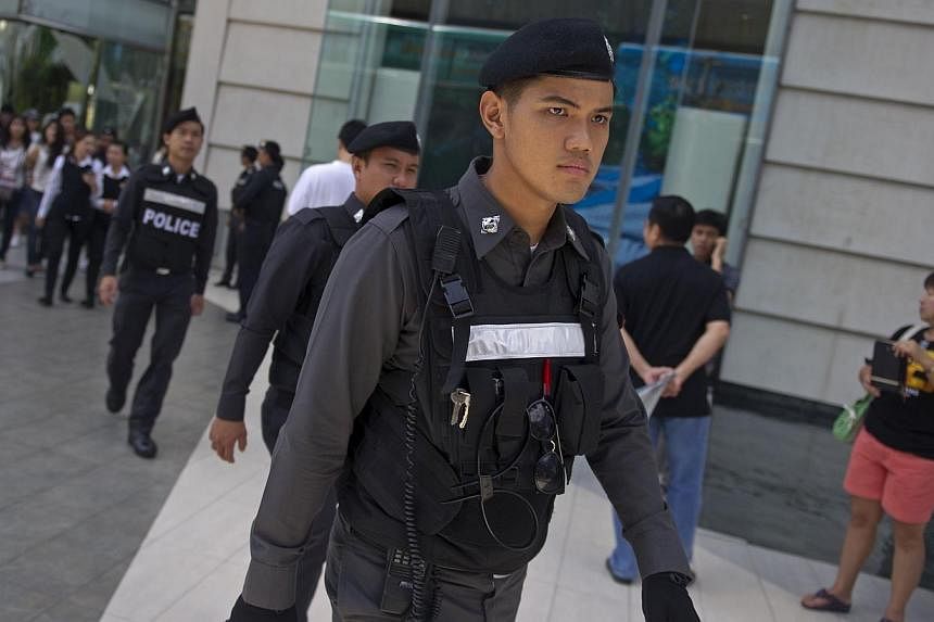 Thai policemen patrol prior to a demonstration by anti-coup protesters at a shopping mall in Bangkok on June 8, 2014.&nbsp;Thailand's junta kept many of the thousands of troops and police it readied to deal with protests in Bangkok on Sunday off the 