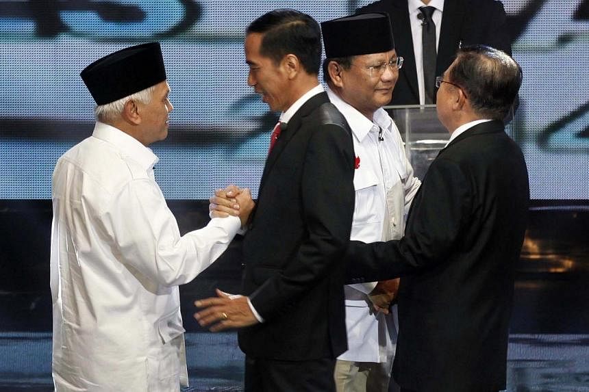Indonesia's vice-presidential candidate Hatta Rajasa (left) greets presidential candidate Joko Widodo (second left), while presidential candidate Prabowo Subianto (second right) greets vice-presidential candidate Jusuf Kalla, before their presidentia