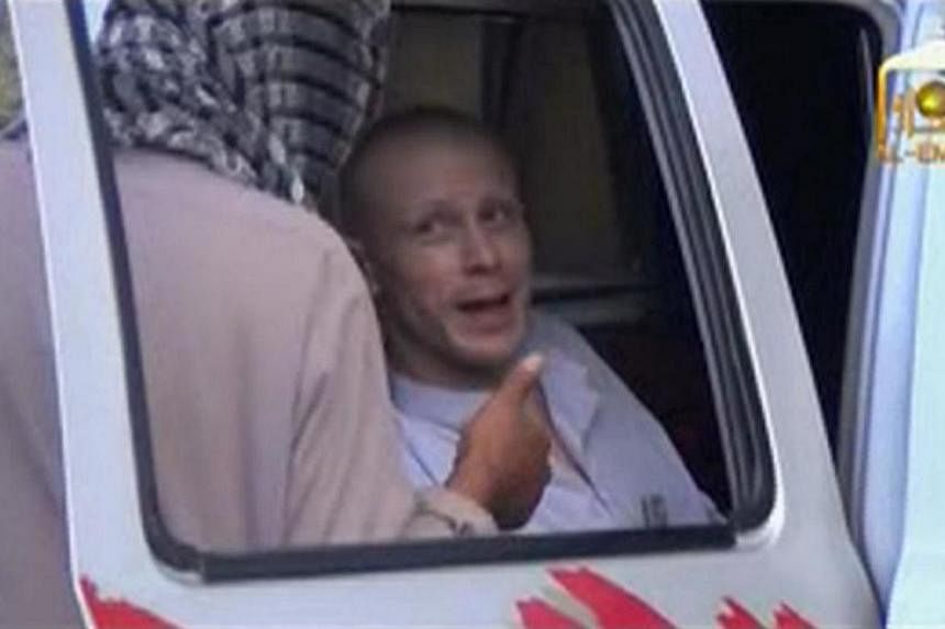 US Army Sergeant Bowe Bergdahl (right) talks to a Taliban militant as he waits in a pick-up truck before his release at the Afghan border, in this still image from video released on June 4, 2014. -- PHOTO: REUTERS