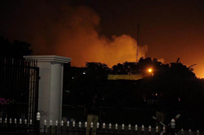 Smoke rises from the burning site of Jinnah International Airport after an assault in Karachi on late June 8, 2014. Heavily armed militants attacked Pakistan's busiest airport in the southern city of Karachi Sunday night. -- PHOTO: AFP