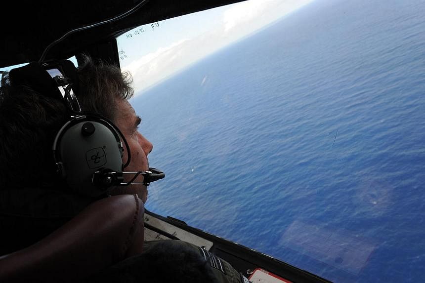 In this file photo taken on April 13, 2014 from a Royal New Zealand Airforce (RNZAF) P-3K2-Orion aircraft, co-pilot and Squadron Leader Brett McKenzie helps to look for objects during the search for missing Malaysia Airlines flight MH370, off Perth. 