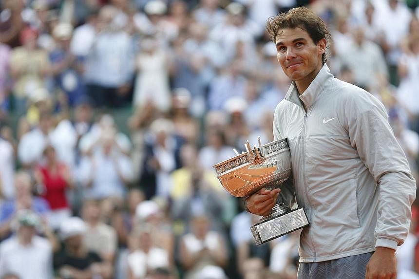 Rafael Nadal of Spain attends the trophy ceremony after defeating Novak Djokovic of Serbia during their men's singles final match to win the French Open Tennis tournament at the Roland Garros stadium in Paris on June 8, 2014. -- PHOTO: REUTERS