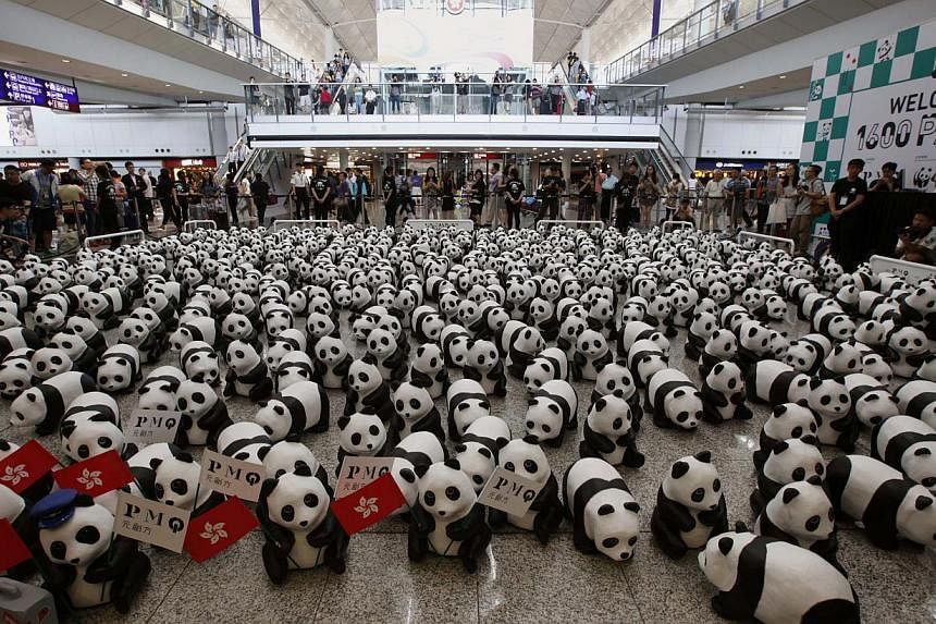 Papier-mache pandas, created by French artist Paulo Grangeon, are seen displayed at the arrival hall of the Hong Kong airport on June 9, 2014. -- PHOTO: REUTERS