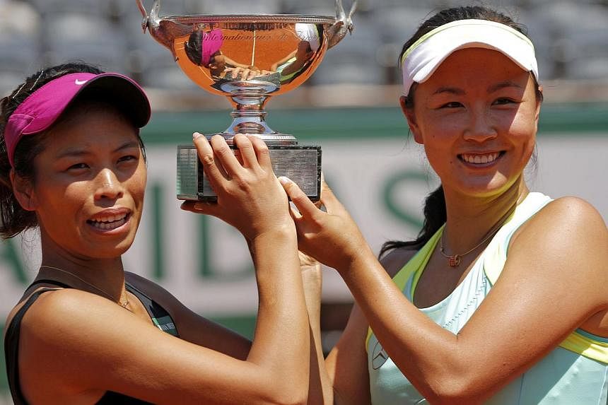 Peng Shuai of China (right) and Hsieh Su-Wei of Taiwan pose with the trophy during the ceremony after winning their women's doubles final match against Sara Errani and Roberta Vinci of Italy at the French Open Tennis tournament at the Roland Garros s