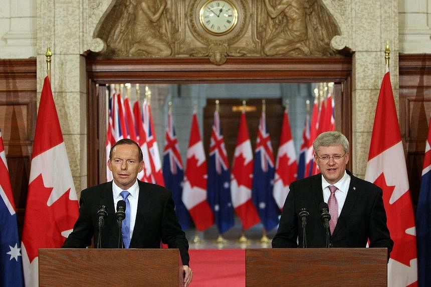 Australian Prime Minister Tony Abbott (left) and Canadian Prime Minister Stephen Harper speak during a joint press conference in Parliament Hill in Ottawa, Canda on June 9, 2014. -- PHOTO: AFP