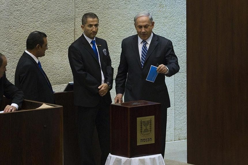 Israel's Prime Minister Benjamin Netanyahu (right) casts his ballot for the presidential election at the Knesset, Israel's Parliament, in Jerusalem on June 10, 2014. Israel's Parliament voted on Tuesday for a new head of state to succeed President Sh