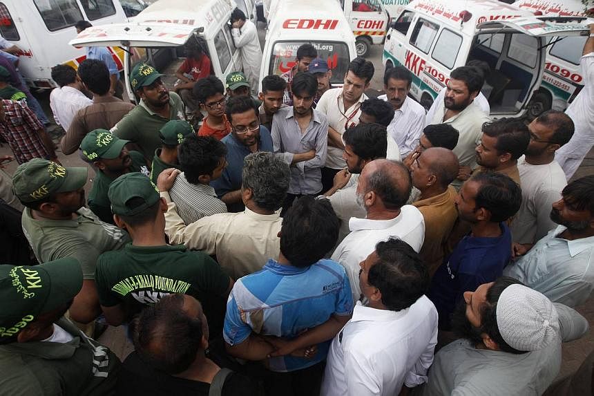 Family members gather to get information and to identify the bodies of victims killed on Sunday's Taleban attack on Jinnah International Airport, outside a hospital morgue in Karachi on June 10, 2014. -- PHOTO: REUTERS