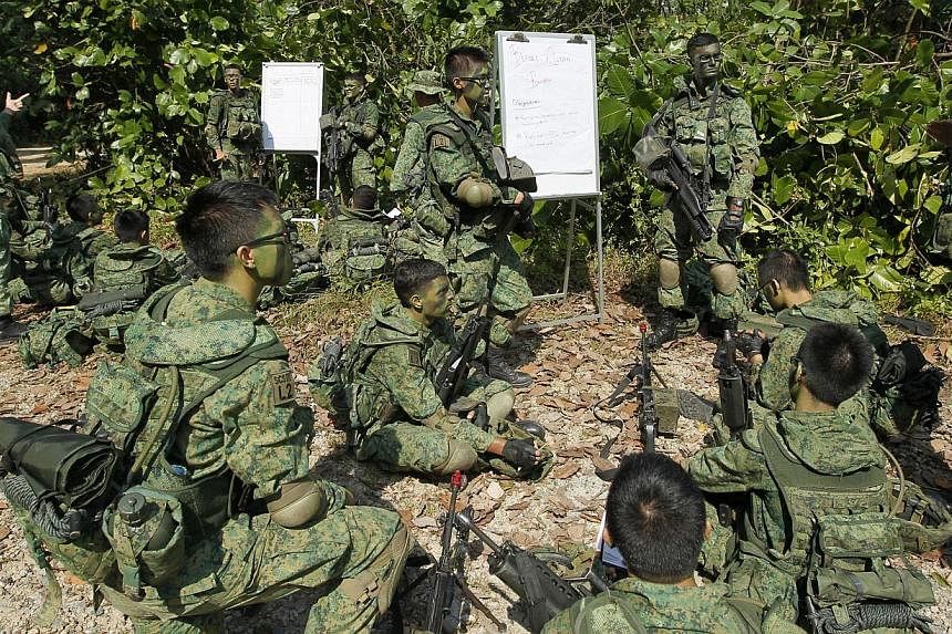 Full-time National Service specialist cadets from Lima Company, Specialist Cadet School, sharing lessons before a training exercise near Pasir Laba Camp, on July 1, 2013. A high-level committee's recommendations to improve NS have been formally accep