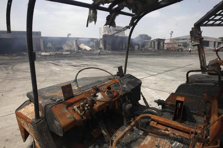 Damaged vehicles are left on the tarmac of Jinnah International Airport, after Sunday's attack by Taleban militants, in Karachi on June 10, 2014.&nbsp;The second attack on Pakistan's Karachi Airport in as many days has ended, a spokesman for the Airp