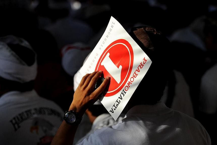 A Balinese supporter holds a poster of Indonesia presidential candidate Prabowo Subianto during their campaign in Denpasar on Bali island on June 6, 2014. -- PHOTO: AFP