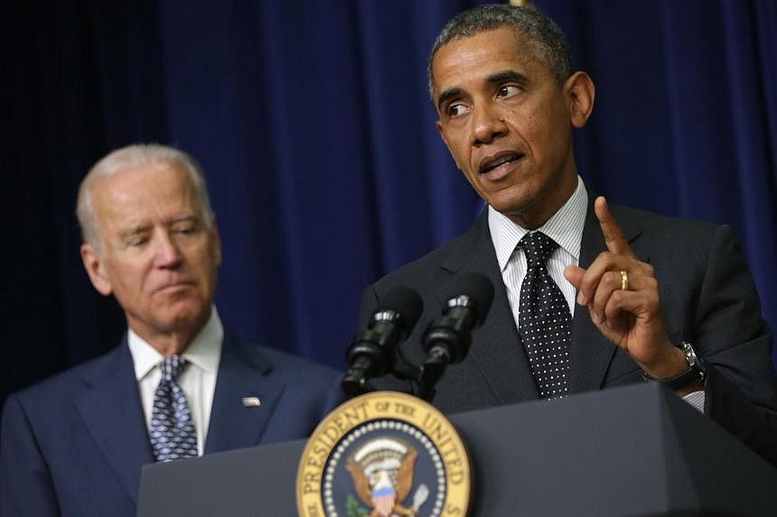 US President Barack Obama (right) speaks as Vice-President Joseph Biden listens during a bill signing ceremony on June 10, 2014. Mr Obama &nbsp;called for national "soul searching" over gun violence, warning that mass shootings were "off the charts" 