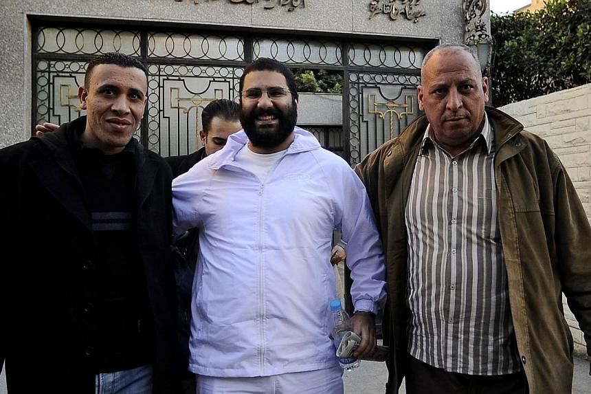 A picture take on Dec 25, 2011, shows Egyptian blogger and activist Alaa Abdel Fattah (centre) exiting the police headquarters in Cairo following his release.&nbsp;An Egyptian court on Wednesday sentenced in absentia Abdel Fattah to 15 years in jail 