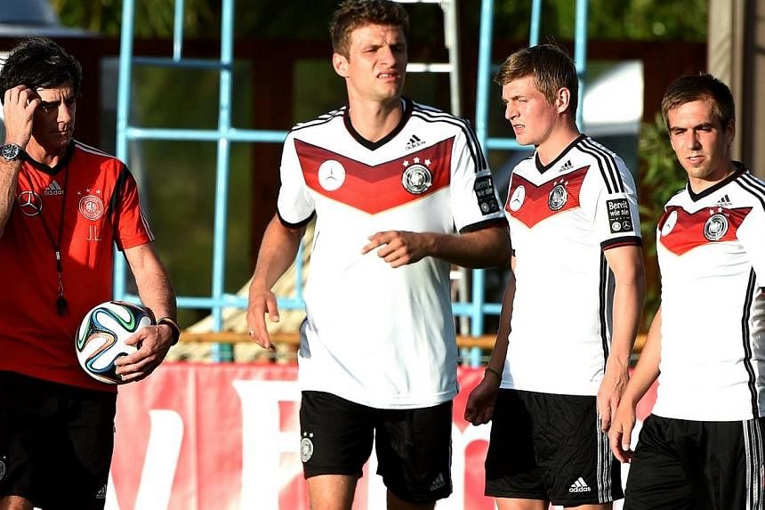 (From left) Germany's coach Joachim Loew stands next to players Thomas Mueller, Toni Kroos and Philipp Lahm during a training session of Germany's national football team in Santo Andre on June 10, 2014. Lahm and Mueller have signed new deals that add