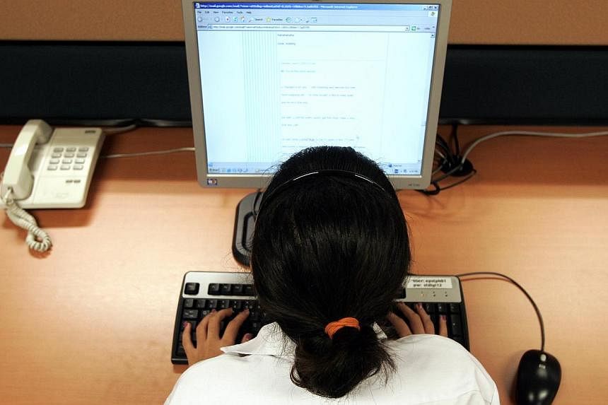 Posed photo of a girl sitting in front of a computer and surfing the internet. -- PHOTO: ST FILE