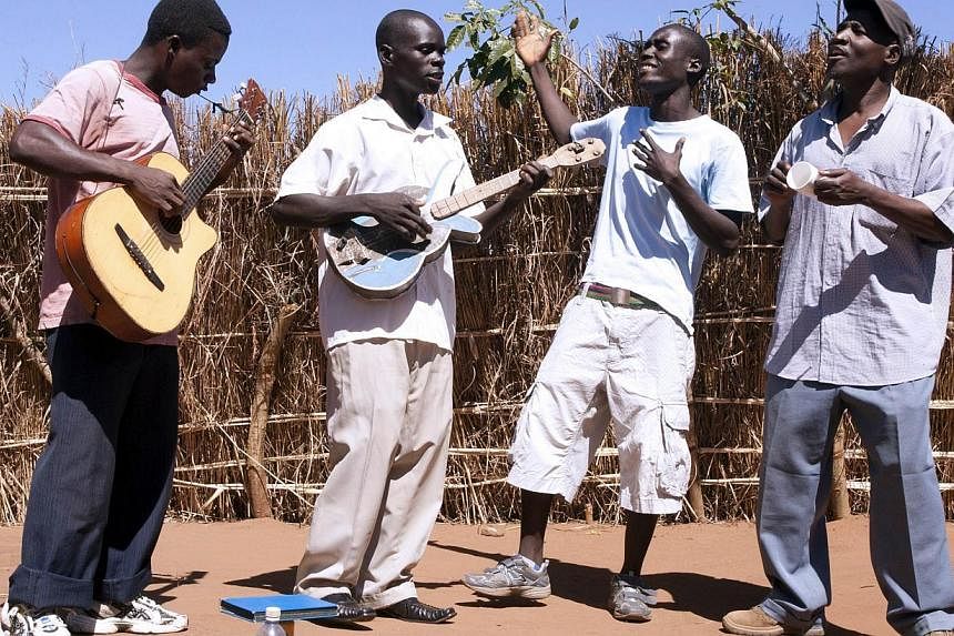 Members of the Malawi Mouse Boys lead vocalist, Zondiwe Kachingwe (left), band leader Nelson Muligo (2nd From left), Alfred Gavana (2nd from right) and backing vocalist Joseph Nekwankwa (right) perform during an interview on May 15, 2014 in the villa