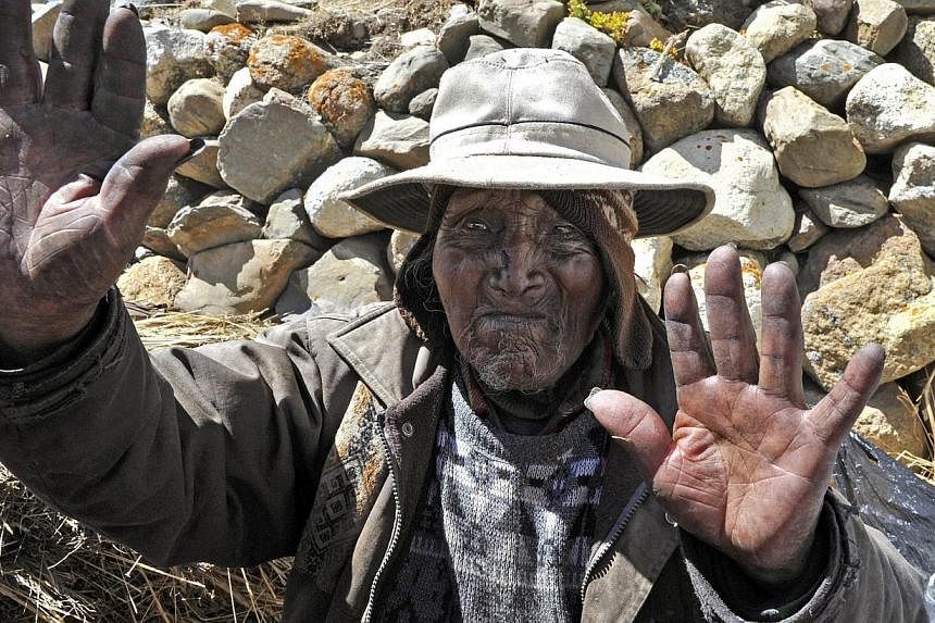 Picture taken on Aug 15, 2013 of Bolivian Carmelo Flores Laura, an Aymara native who claims is 123 years old and if confirmed would be the oldest man alive, waves outside his house in the community of Frasquia, 4050 metres above sea level, on the foo