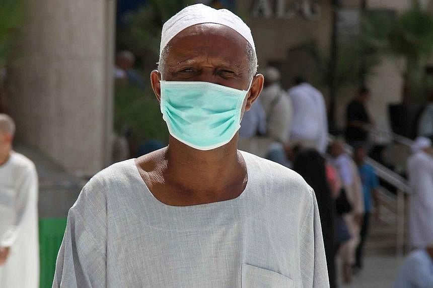 An Asian Muslim pilgrim wears a nose and mouth mask on his way to Islam's holiest shrine, the Kaaba, in the Grand Mosque in the Saudi city of Mecca in Saudi Arabia on May 27, 2014. -- PHOTO: AFP