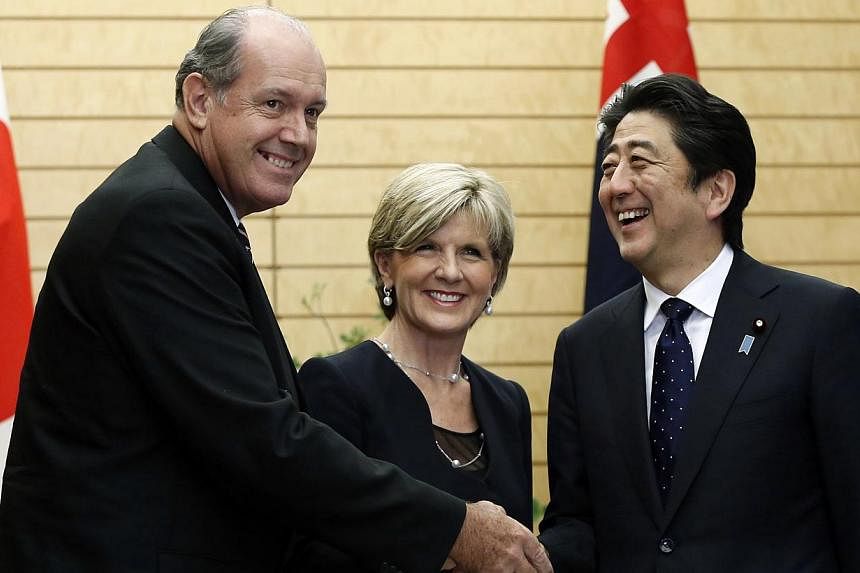 Australian Defence Minister David Johnston (left) and Australia's Foreign Minister Julie Bishop (centre) shake hands with Japan's Prime Minister Shinzo Abe at Mr Abe's official residence in Tokyo on June 11, 2014.&nbsp;-- PHOTO: REUTERS