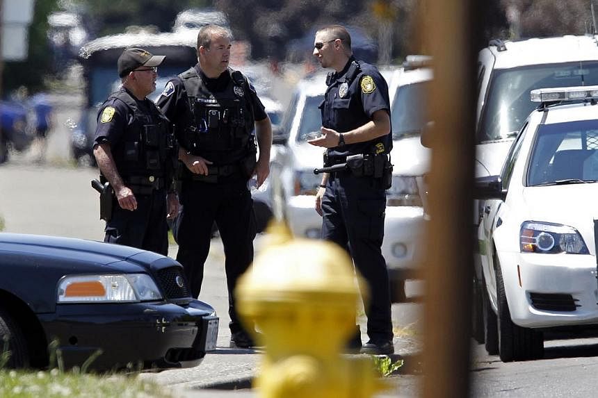 Police officers stand on the sidewalk after a shooting at Reynolds High School in Troutdale, Oregon on June 10, 2014. -- PHOTO: REUTERS