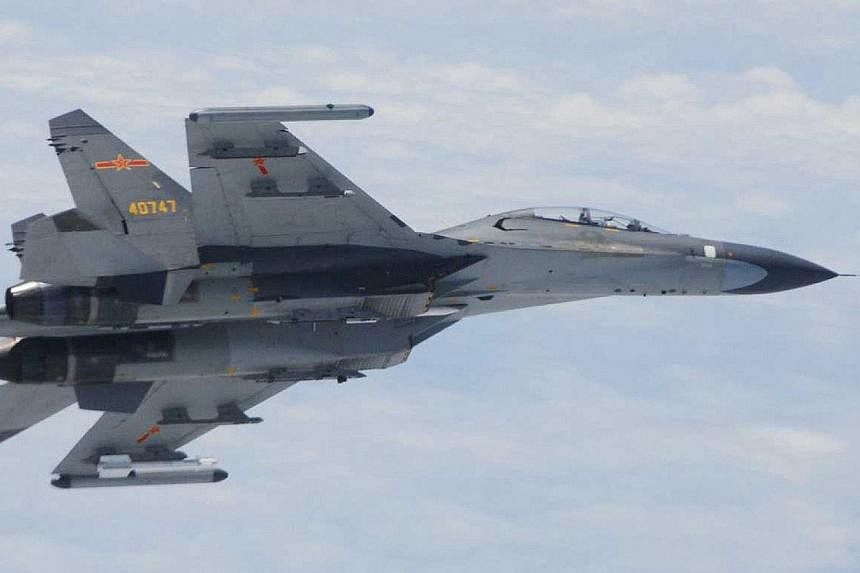 This picture taken and released by Japan's Defence Ministry on June 11, 2014 and received via Jiji Press shows one of two Chinese Su-27 fighter jets which flew "dangerously" close to two Japanese military planes over the East China Sea. Japan accused