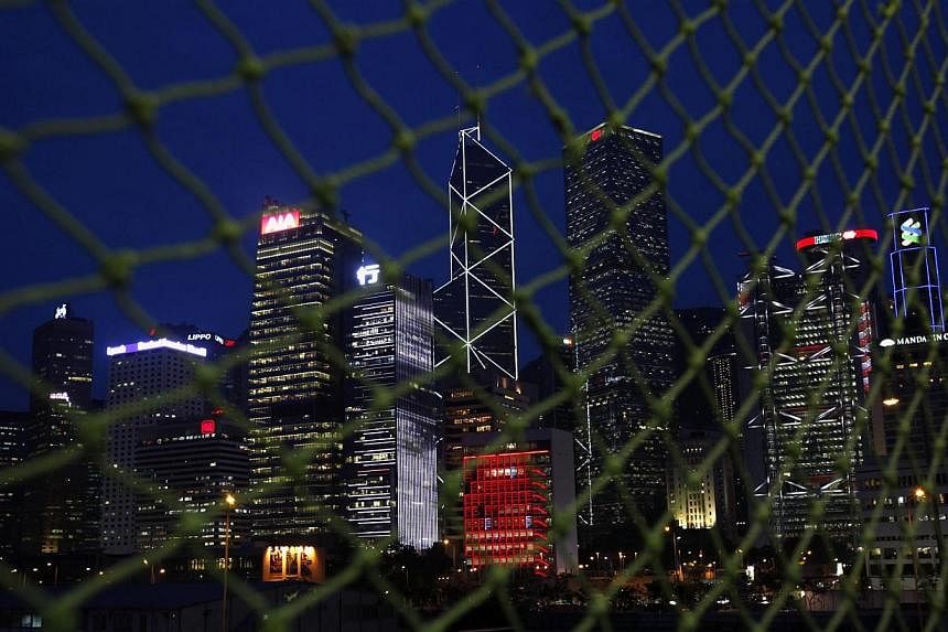 Skyscrapers at Hong Kong's central business district (from left),&nbsp;AIA Central, CCB Tower, Bank of China Tower, City Hall (in red), Cheung Kong Centre, HSBC headquarters and Standard Chartered Bank are seen behind a net near a construction site m