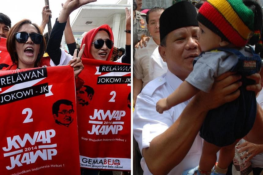 Supporters of presidential candidates Joko Widodo and Jusuf Kalla with banners and posters (left) in Bandung, West Java. Their rival Prabowo Subianto (right) is seen carrying an infant, also in Bandung. -- PHOTOS: AGENCE FRANCE-PRESSE, BLOOMBERG