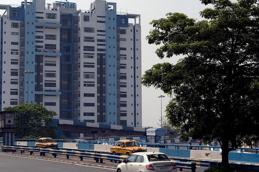 In this photograph taken on June 12, 2014, cars drive past the state secretariat building called "Nabanna", painted in shades of blue in Kolkata. -- PHOTO: AFP