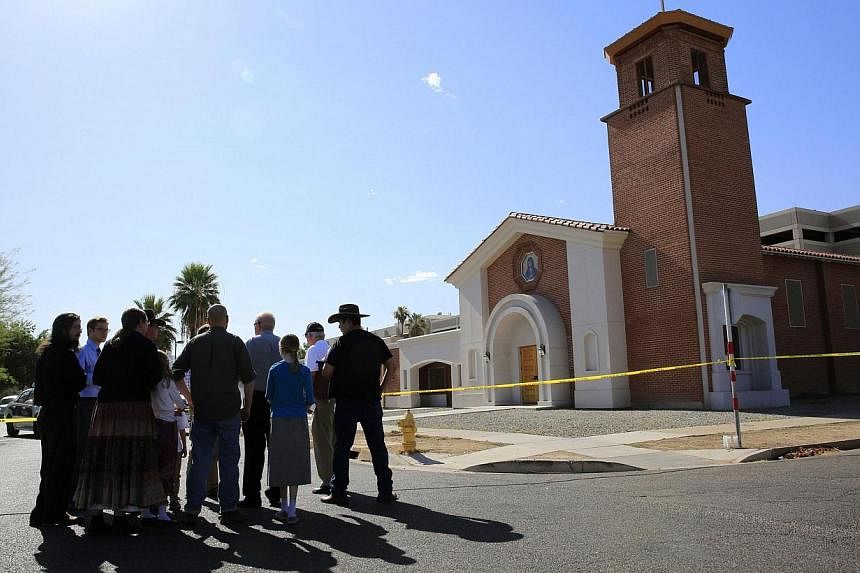 Parishioners arrive to pray, outside the Mater Misericordiae (Mother of Mercy) Mission Catholic church in Phoenix, Arizona on June 12, 2014.&nbsp;Police were hunting for a gunman or gunmen who killed one priest and injured another at a Catholic churc