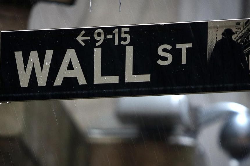 A Wall Street sign is pictured in the rain outside the New York Stock Exchange in New York on June 9, 2014. -- PHOTO: REUTERS