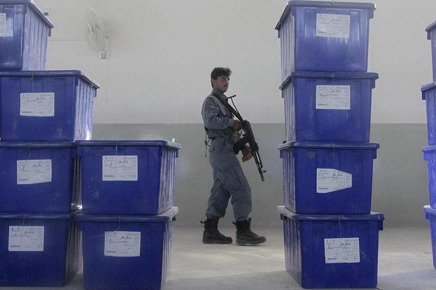A man keeps watch at a warehouse where ballot boxes bound for remote areas are kept, on the outskirts of Jalalabad city on June 12, 2014. -- PHOTO: REUTERS
