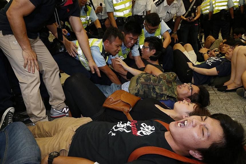 A protester shouts as police officers try to drag another protester away during a confrontation outside the Legislative Council in Hong Kong early on June 14, 2014. -- PHOTO: REUTERS