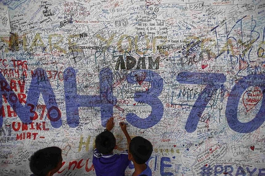 Children write messages of hope for passengers of missing Malaysia Airlines Flight MH370 at Kuala Lumpur International Airport (KLIA) outside Kuala Lumpur June 14, 2014.&nbsp;A commercial pilot has co-written a book on missing Malaysian Airlines Flig