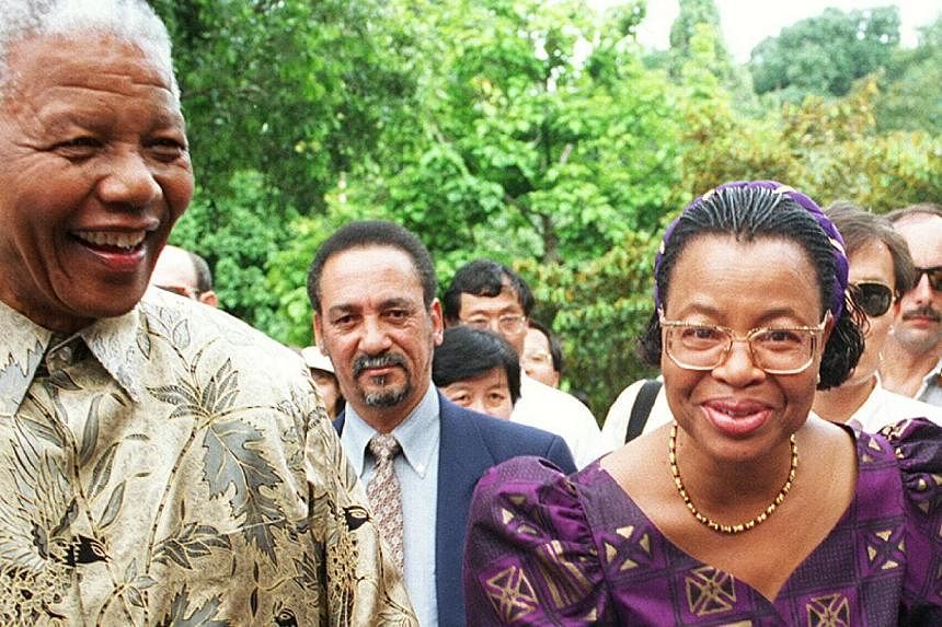 Mr Nelson Mandela's widow Graca Machal (right, pictured with Mr Mandela) was treated badly by members of his family as the peace icon was fighting for his life in hospital, excerpts from a memoir by his long-time aide have revealed. -- ST FILE PHOTO