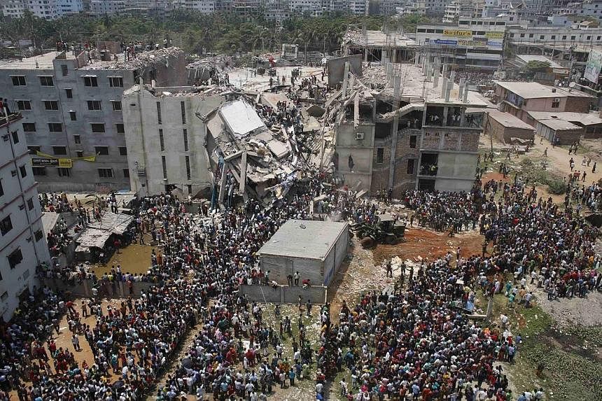 Crowds gather at the collapsed Rana Plaza building as people rescue garment workers trapped in the rubble, in Savar, 30km outside Dhaka in this April 24, 2013 file photo.&nbsp;Bangladesh's Anti-Corruption Commission (ACC) on Sunday filed a case with 
