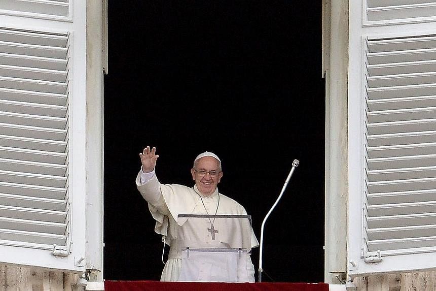 Pope Francis waves from the window of his study overlooking St.Peter's Square at the Vatican as he leads the Sunday Angelus prayer on June 15, 2014.&nbsp;Pope Francis said on Sunday, June 15, 2014, his first trip to a European country would be to Alb