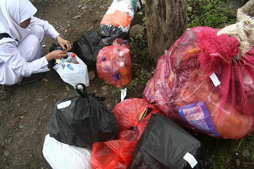 In this photograph taken on April 26, 2014, an Indonesian nurse at Klinik Bumi Ayu in Malang in the main island of Java, collects packs of recyclable garbage delivered by members of the clinic. Registered members of the unique clinic are mostly Indon