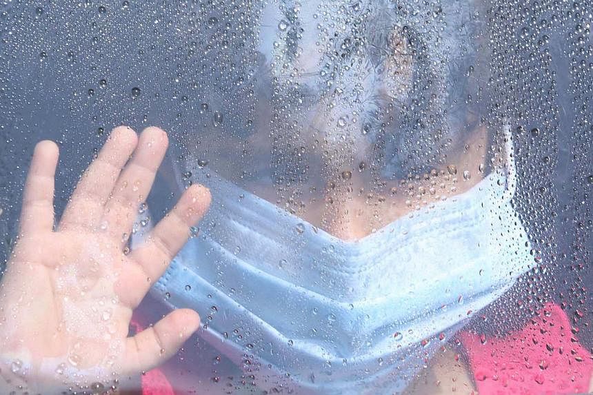 A girl wearing a mask looks out a car window as rain drops are seen in Taif, Saudi Arabia, on June 7, 2014. Saudi Arabia announced last week that it had found 113 more cases of the deadly Middle East Respiratory Syndrome (Mers). -- FILE PHOTO: REUTER