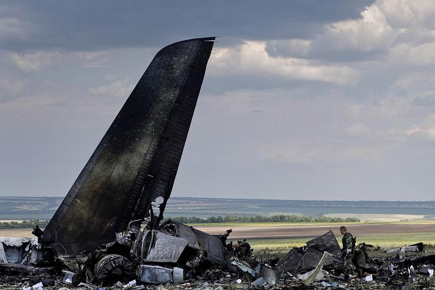 Pro-Russian separatists look through the debris of an IL-76 transporter which was taken down by pro-Russian rebels early on June 14, on the outskirts of Lugansk on June 14, 2014.&nbsp;Ukraine’s president promised a tough response on Saturday to pro