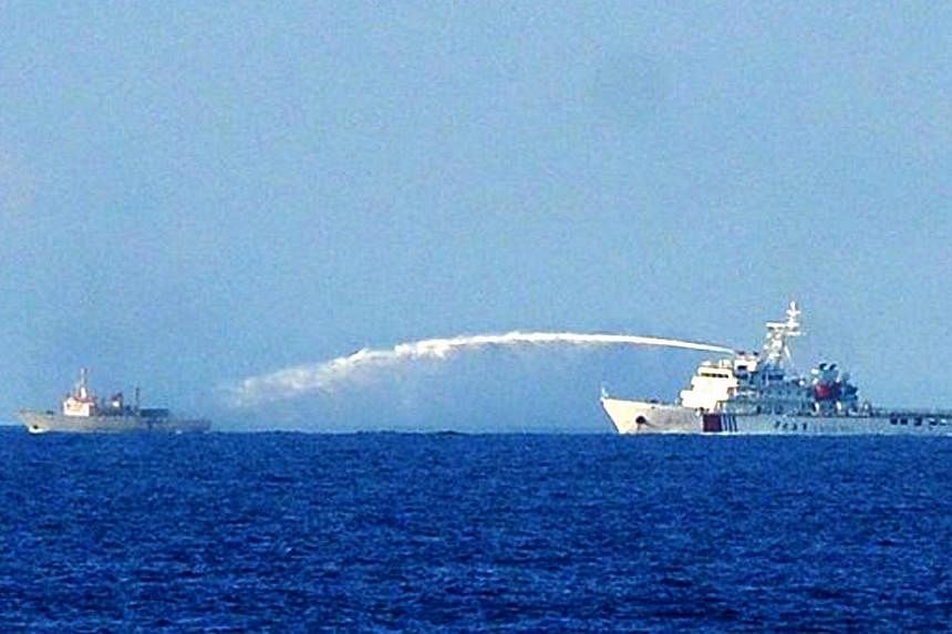 This picture taken on June 2, 2014 shows a Chinese Coast Guard ship (right) using a water cannon to attack a Vietnamese Fisheries Surveillance boat near to the site of the Chinese oil rig in disputed waters of the South China Sea off Vietnam's centra