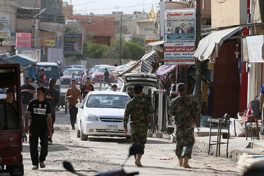 Iraqis walks along a street in the town of Bartala, on June 15, 2012, east of the northern city of Mosul, as some Iraqi police and security remain in the town to protect the local churches and community. The Obama administration is mulling possible d